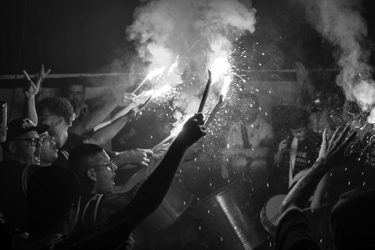Fans in der Kurve mit brennenden Leuchtfackeln
